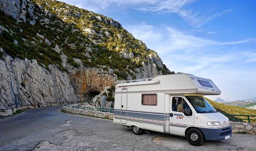 Bild eines Camping-Vans vor schöner Aussicht.