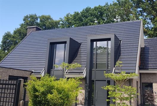 Bild eines Hausdachs mit integrierten Solarpanels in den Dachziegeln.